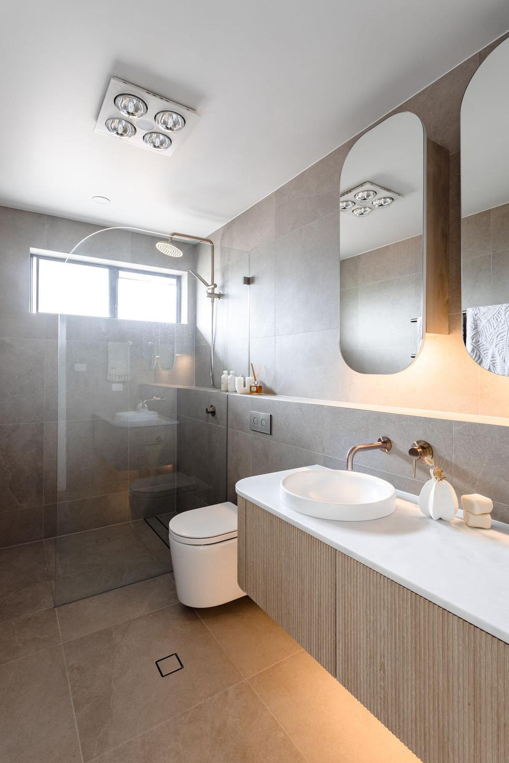 Beige tiles and soft curves in this serene tonal bathroom