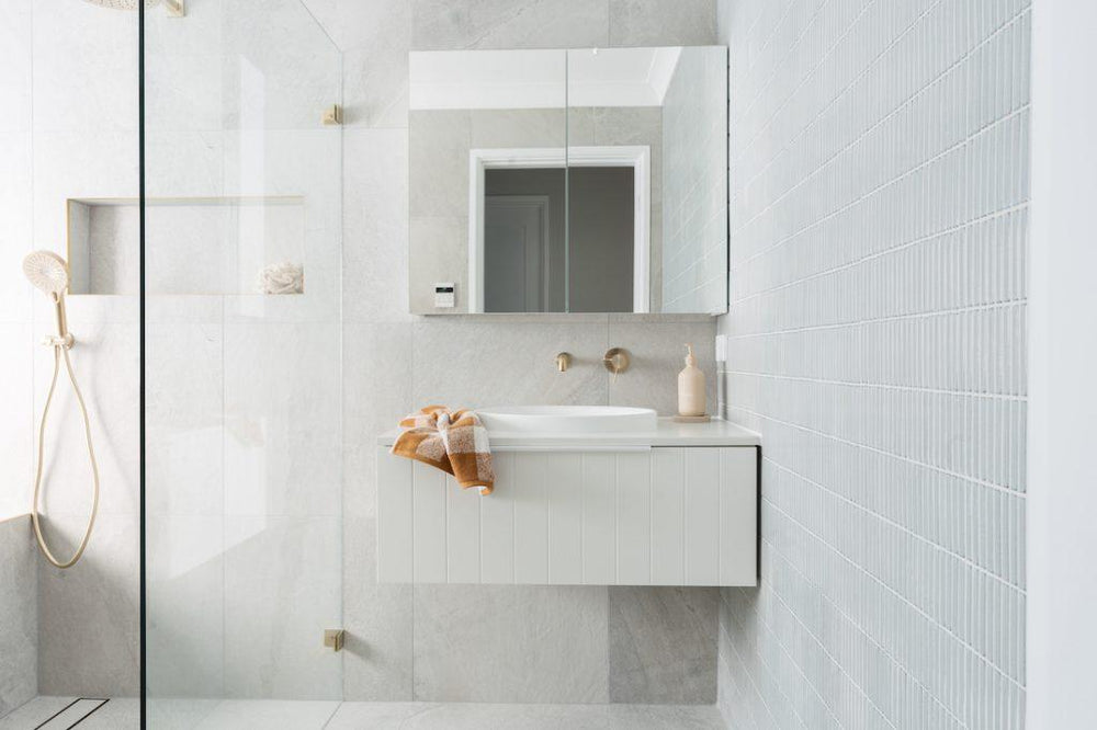 Luxe bathroom renovation featuring grey stone-look tiles and vintage grey finger mosaics