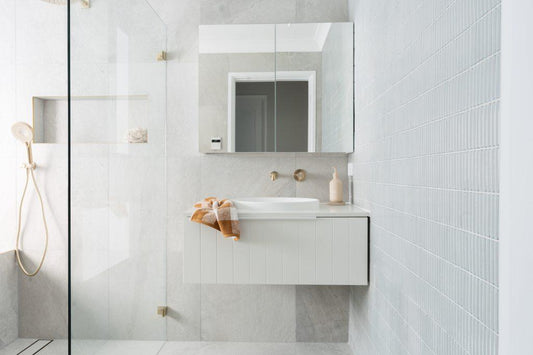 Luxe bathroom renovation featuring grey stone-look tiles and vintage grey finger mosaics