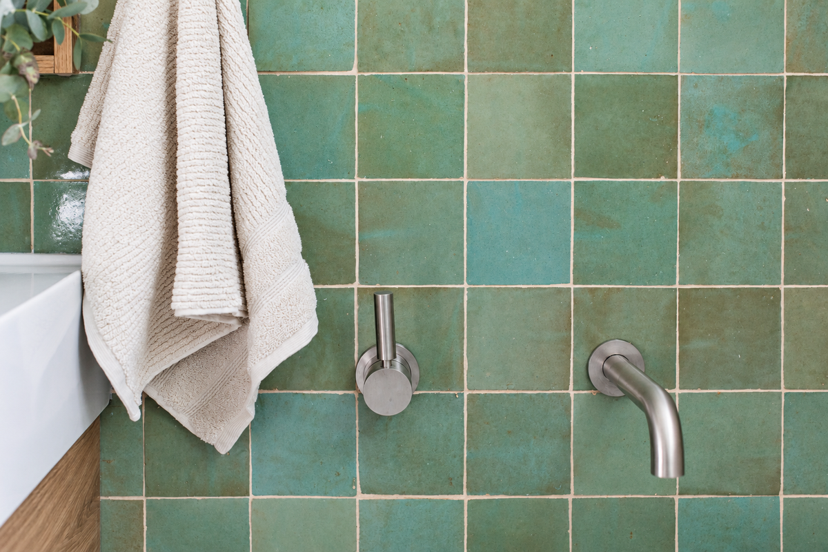 Sage green Zellige wall tiles with brushed metal tapware