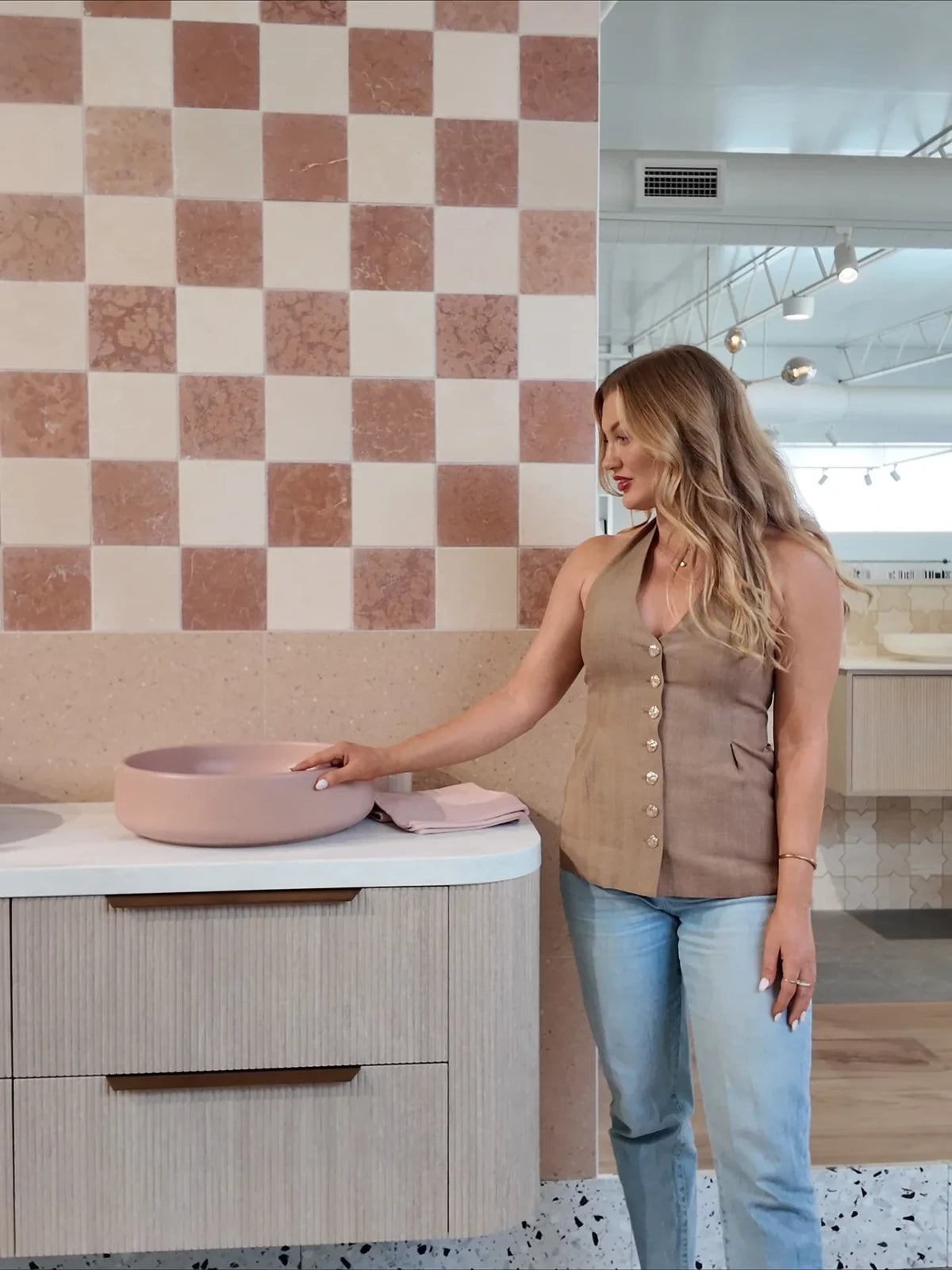 Showroom consultation beside a blush basin and checkerboard tiles